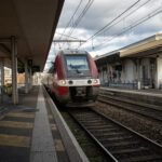 a red and white train pulling into a train station